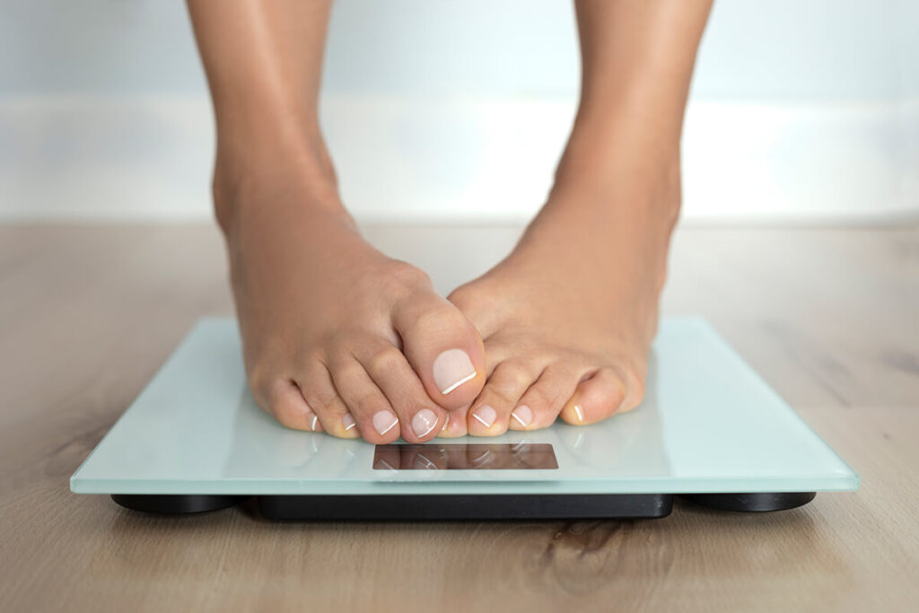 woman standing on scales measuring weight